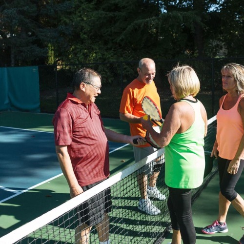 a group of people standing on a Pickleball court