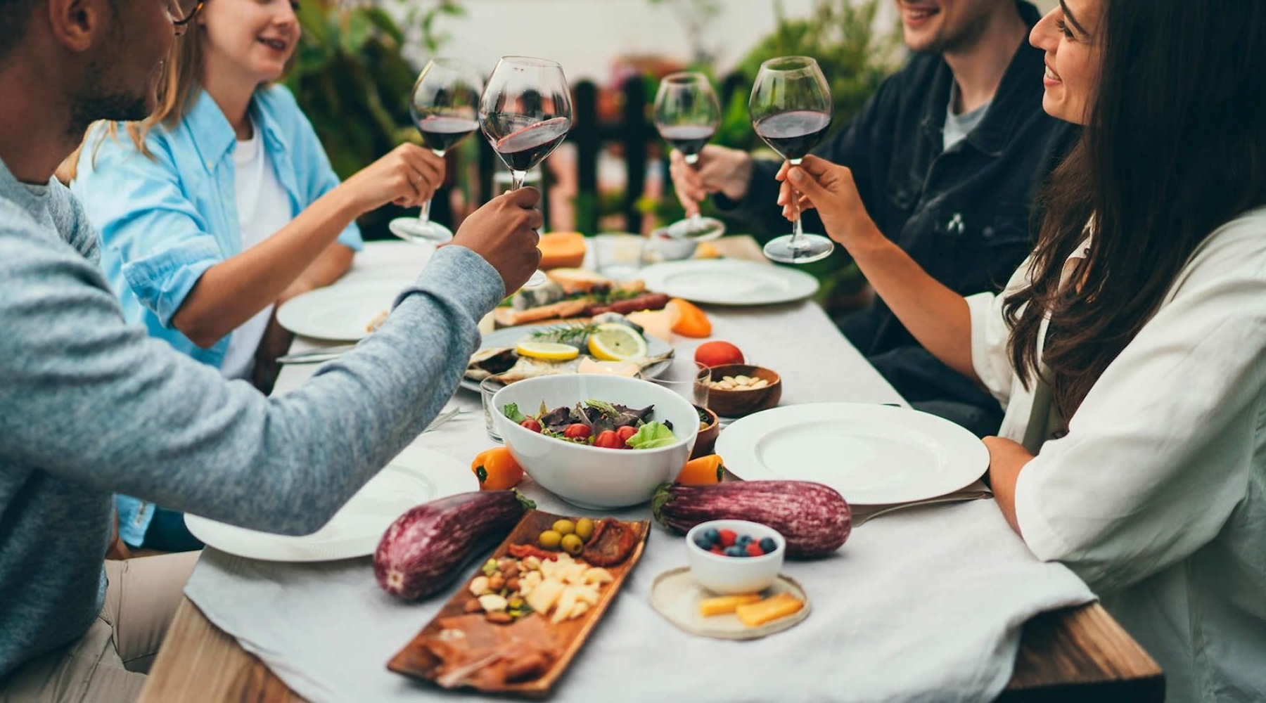 a group of people having a meal around an outdoor table